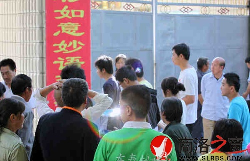 家們送考生進入考場時，一縷光環(huán)閃現(xiàn)鏡頭中，這也許就是人們的理想與期待.jpg
