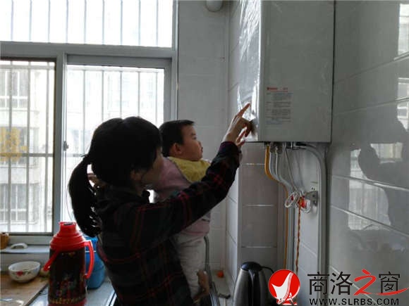 家住市區(qū)香菊小區(qū)的李女士正在操作自家剛剛安裝的燃氣壁掛爐，提升室內的溫度。