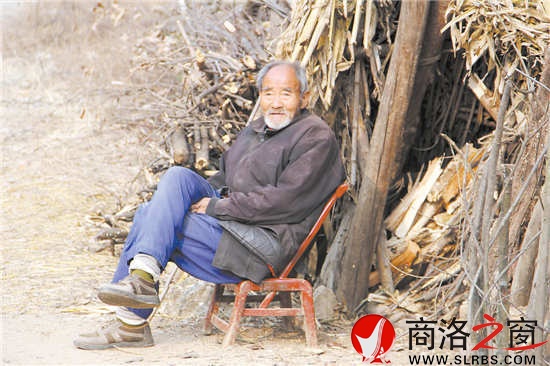 花白胡子的趙恩老人靠著柴垛悠閑地聽(tīng)著秦腔戲