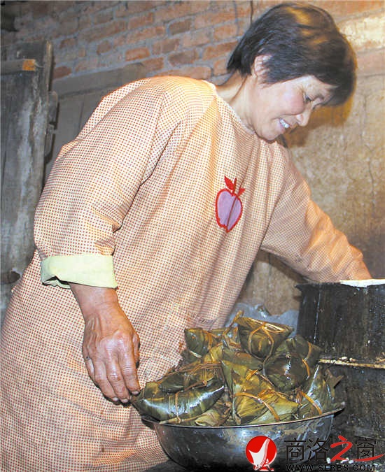 凌晨4:20，風(fēng)建霞正從鍋里往外撈粽子。
