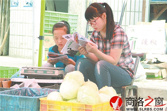商州區(qū)楊斜鎮(zhèn)集市上，南思佳和妹妹在幫父母賣(mài)菜，閑暇之余，她們會(huì)拿起課外讀物翻一翻。在這個(gè)假期里，她們呆的最多的地方就是這個(gè)菜攤。